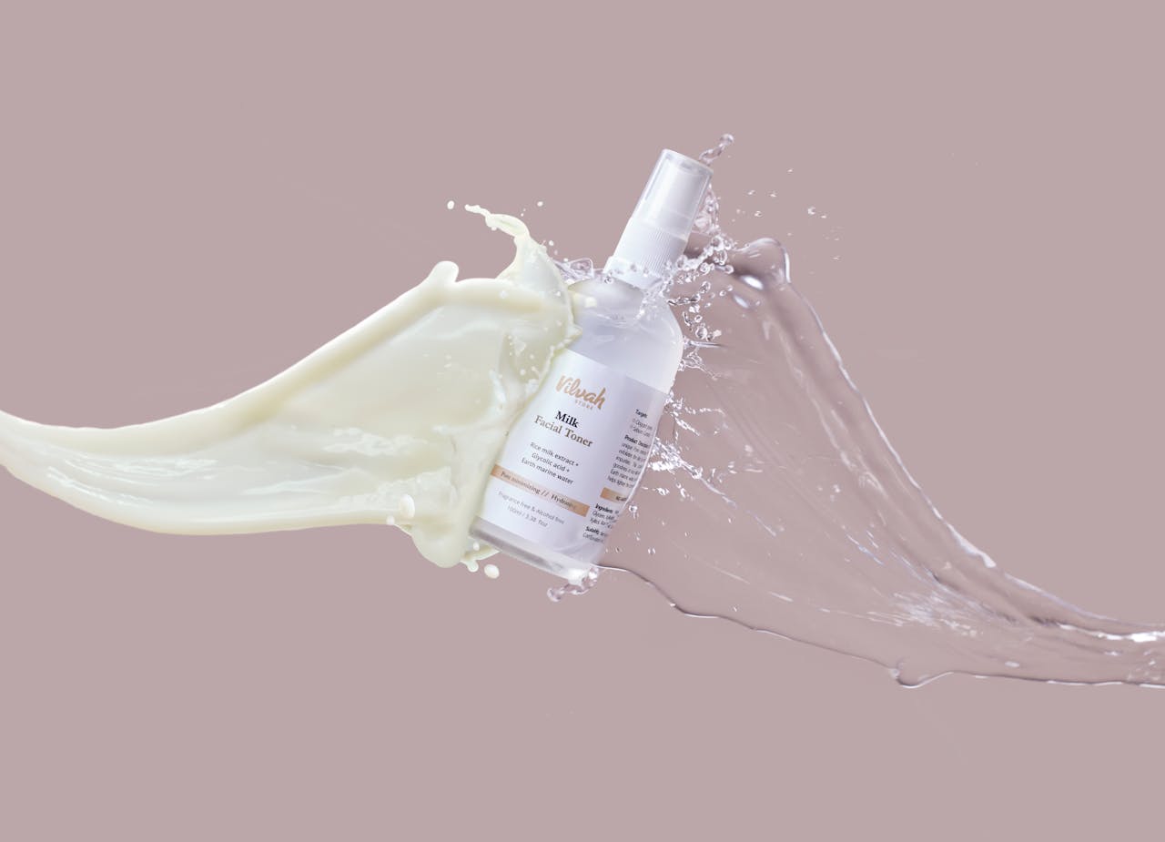 why-choose-us High-speed capture of milk and water splashing around a facial toner bottle, highlighting skincare product.